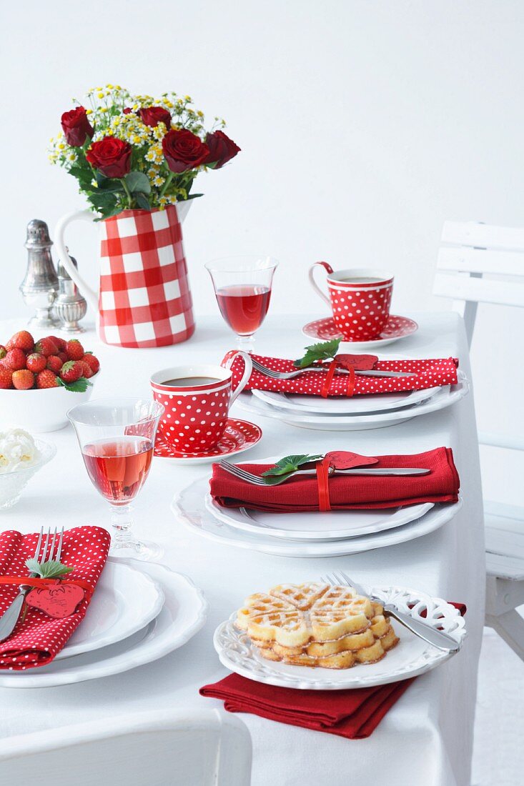 Gedeckter Tisch mit Erdbeeren und Waffeln