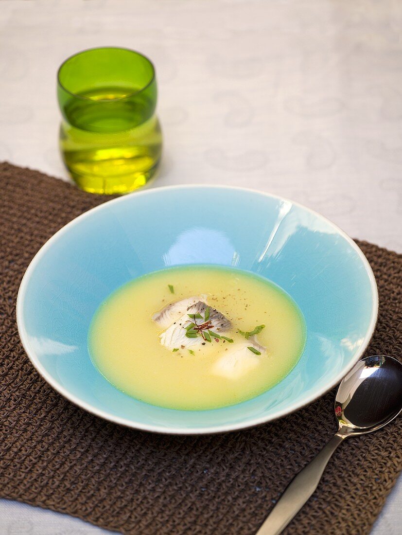 A plate of fish soup with fish fillet