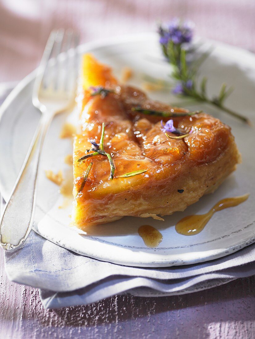 Ein Stück Tarte Tatin mit Rosmarin