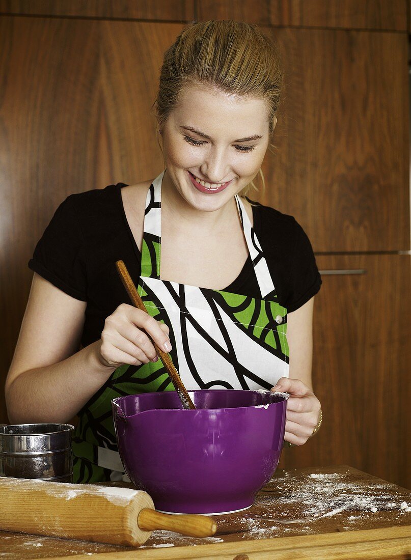 Woman stirring baking mixture in a mixing bowl