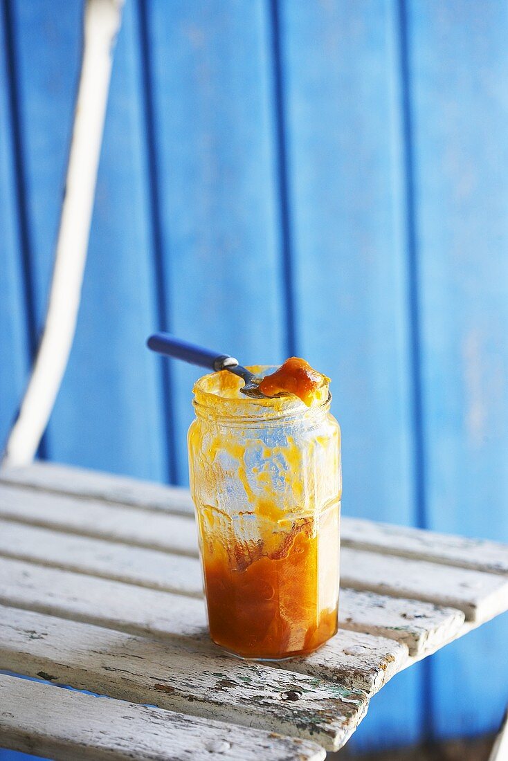 A jar of apricot jam on garden chair