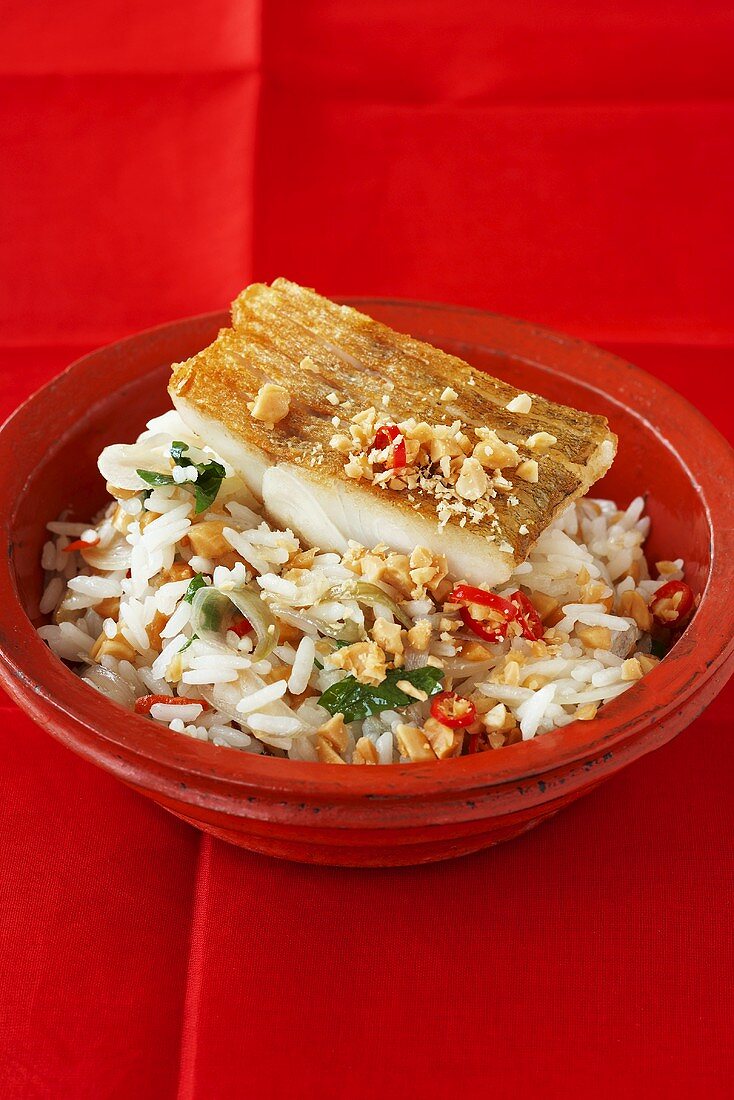 Fried zander on rice with peanuts and chilli