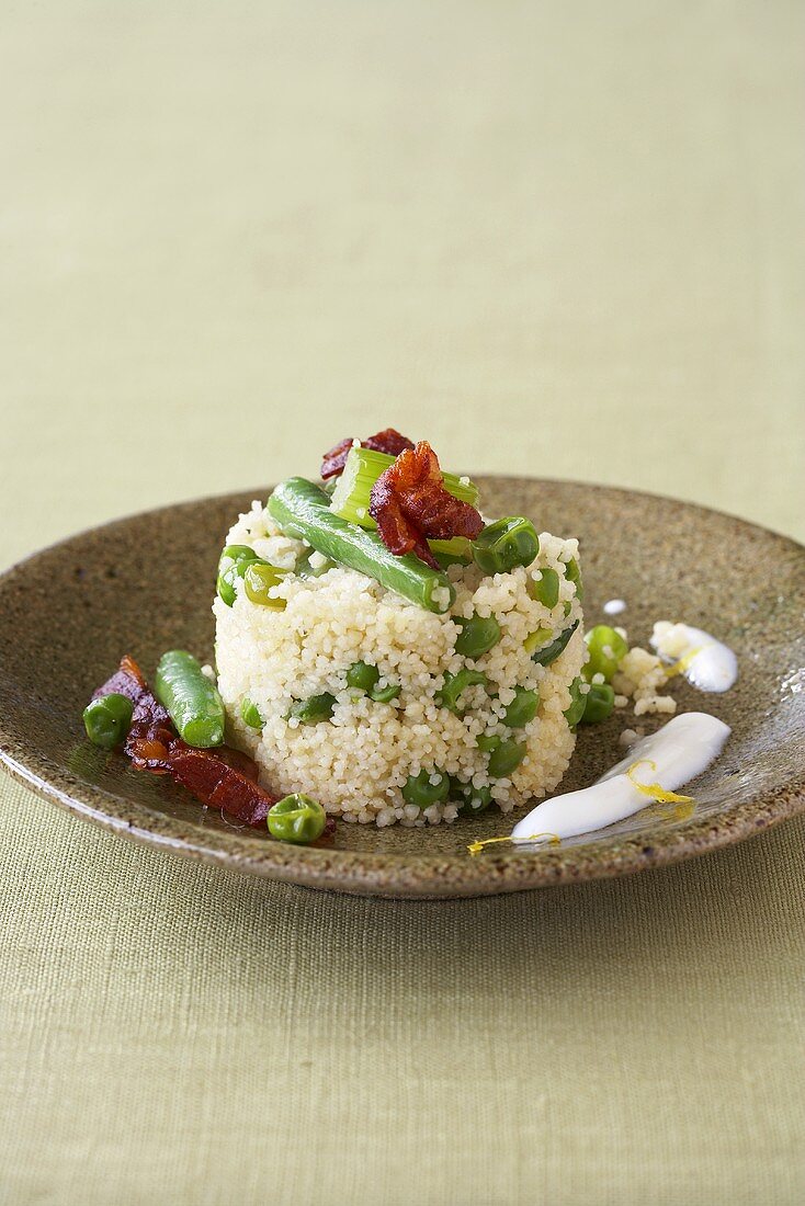 Couscous with vegetables, fried bacon and yoghurt sauce