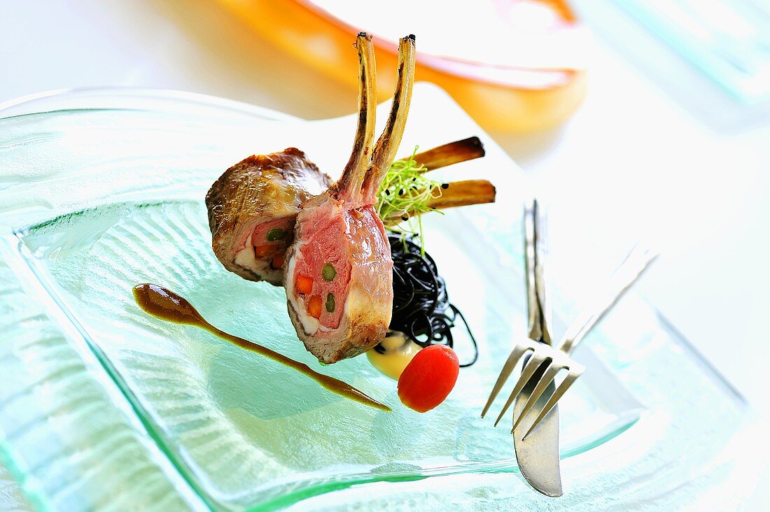 Rack of lamb stuffed with asparagus & carrots, squid ink pasta