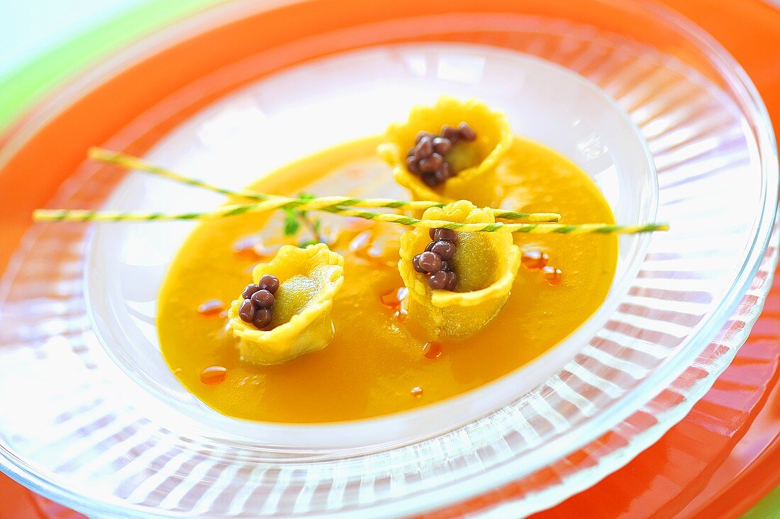 Butternut squash soup with cep ravioli and truffle pearls