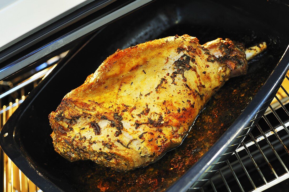 Roast leg of lamb with rosemary in roasting tin