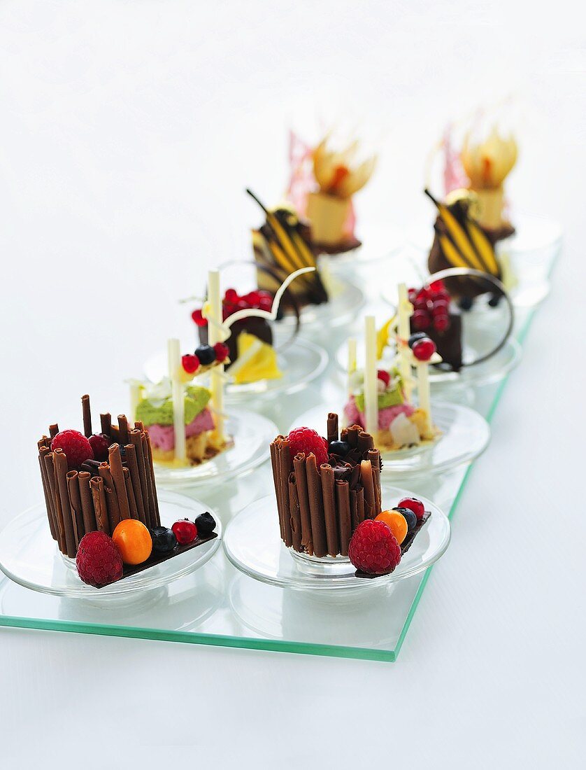 Verschiedene Schokoladen-Fruchtdesserts auf einer Glasplatte