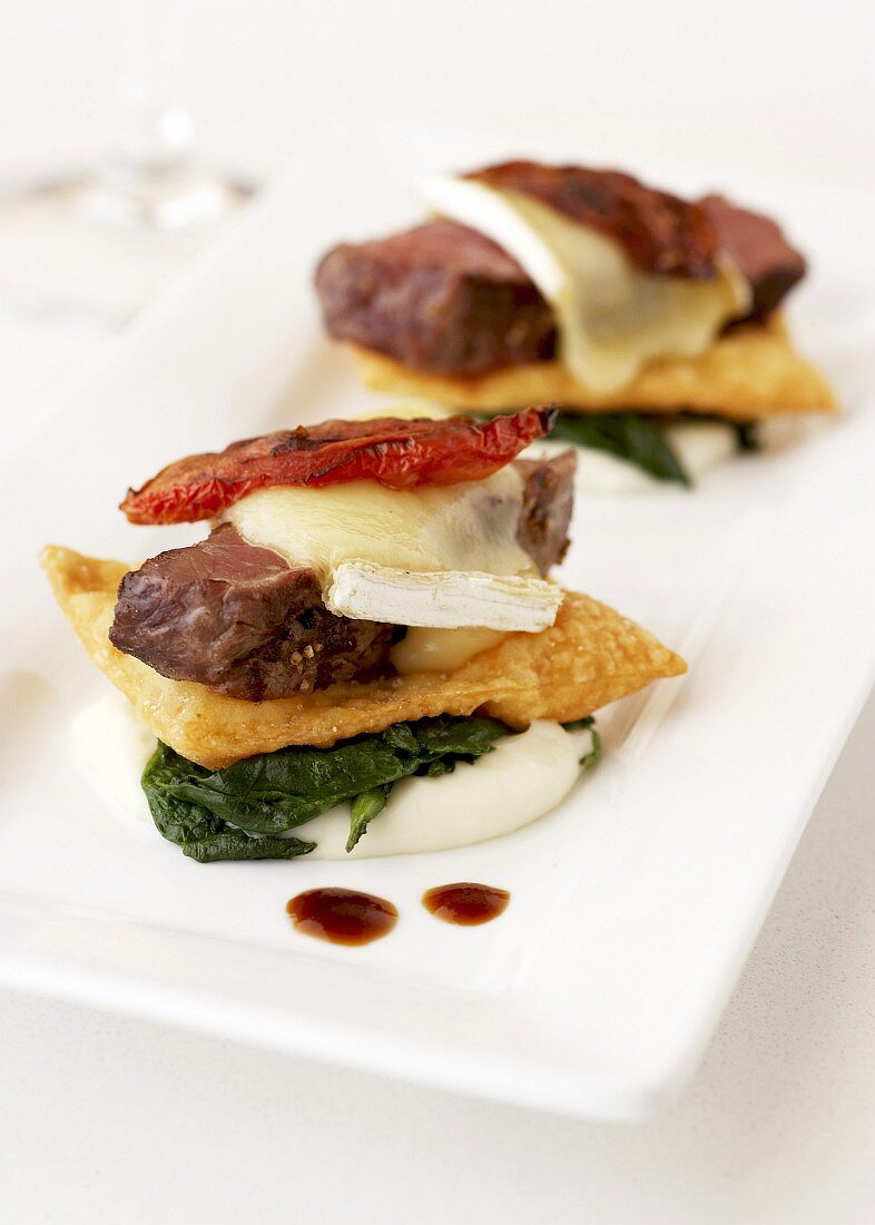 Beefsteak with spinach and melted cheese (appetiser)