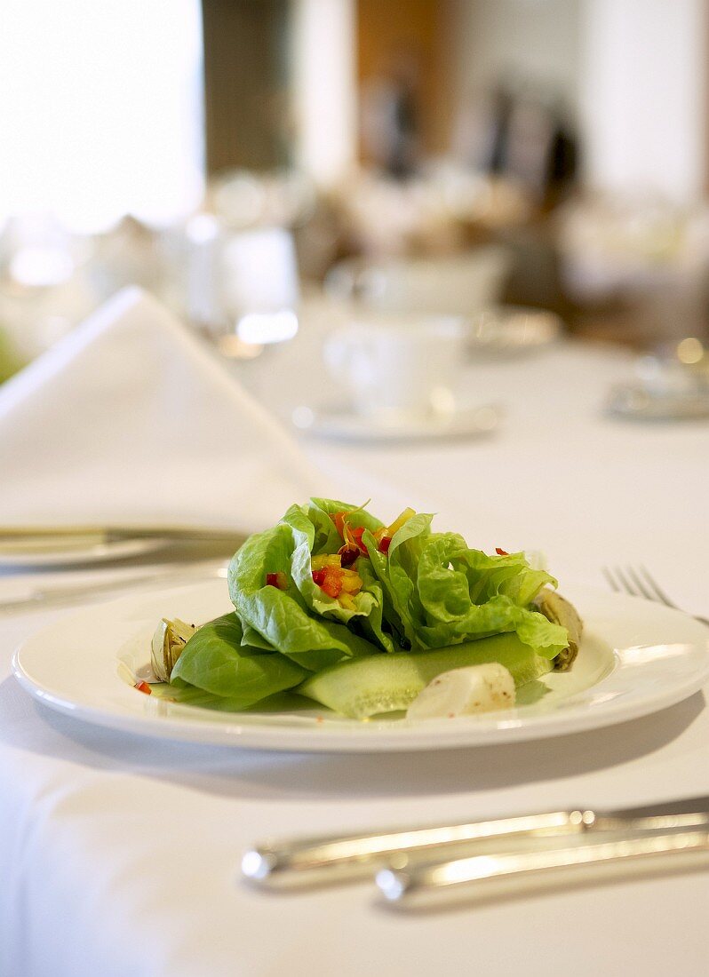 Grüner Salat auf festlich gedecktem Tisch