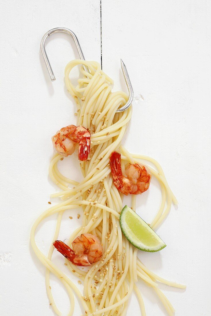 Spaghetti with prawns and sesame seeds hanging on a hook