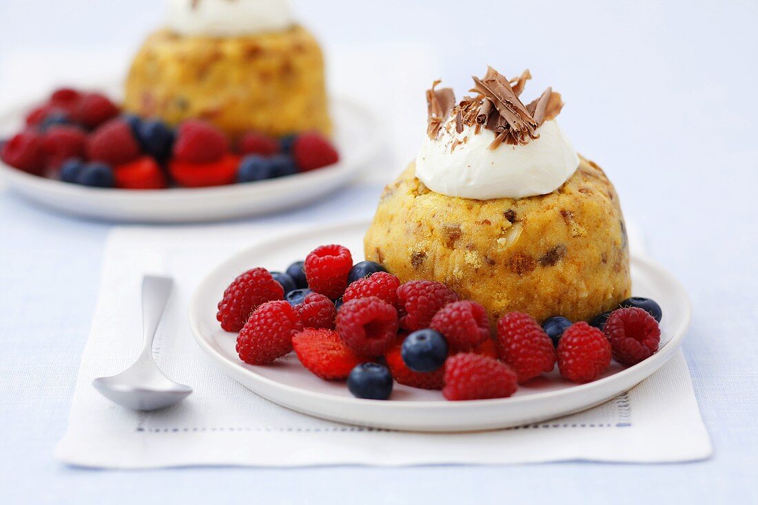 Dried fruit sponge dumpling with whipped cream and berries