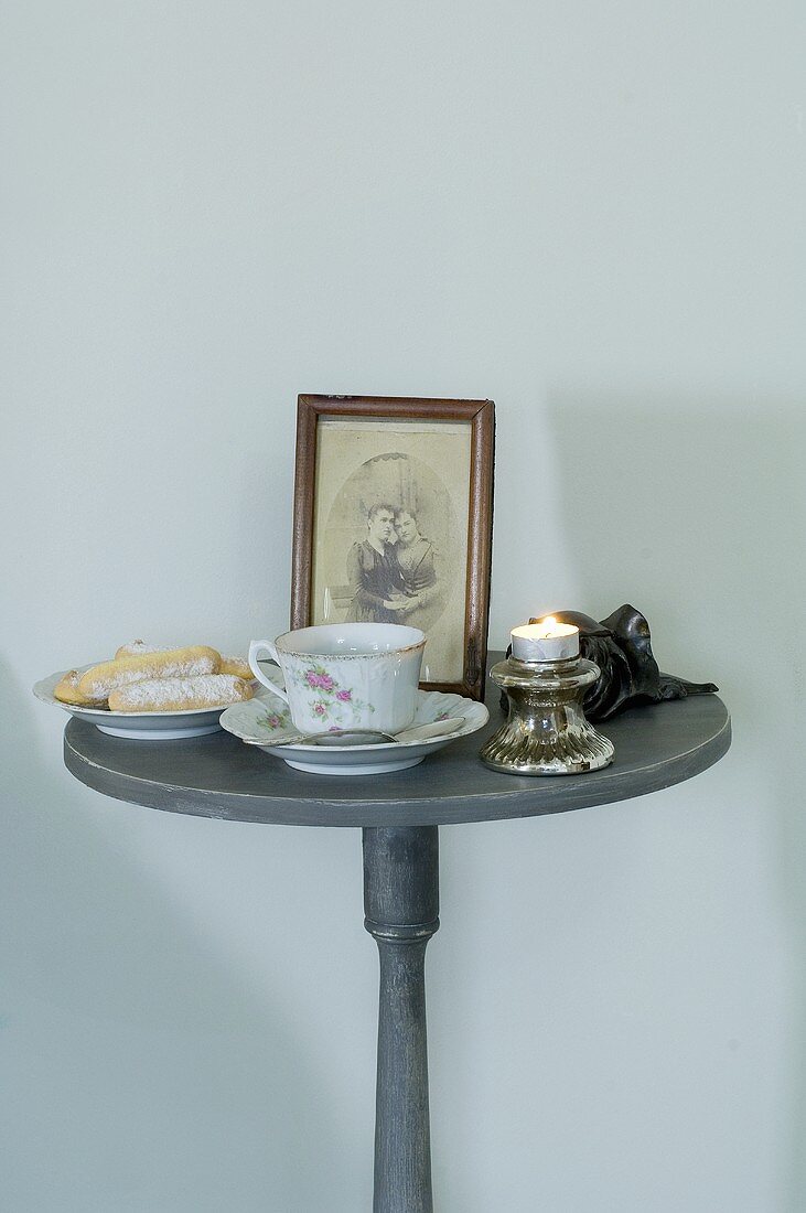 Runder Tisch mit Tasse, Biscuits, Foto und Teelicht