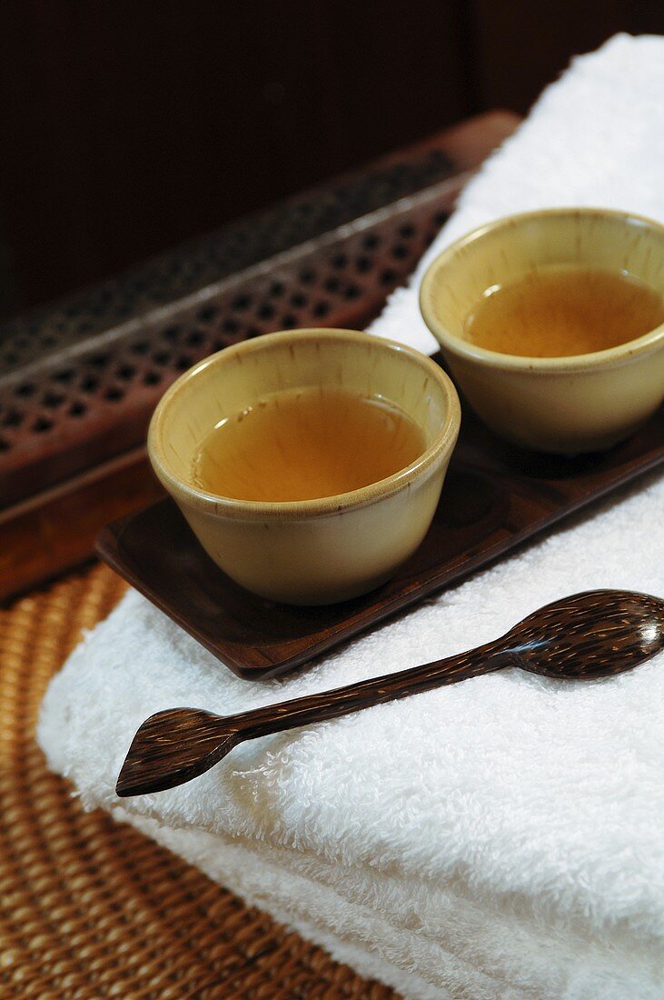 Two bowls of tea, towels and wooden spoon