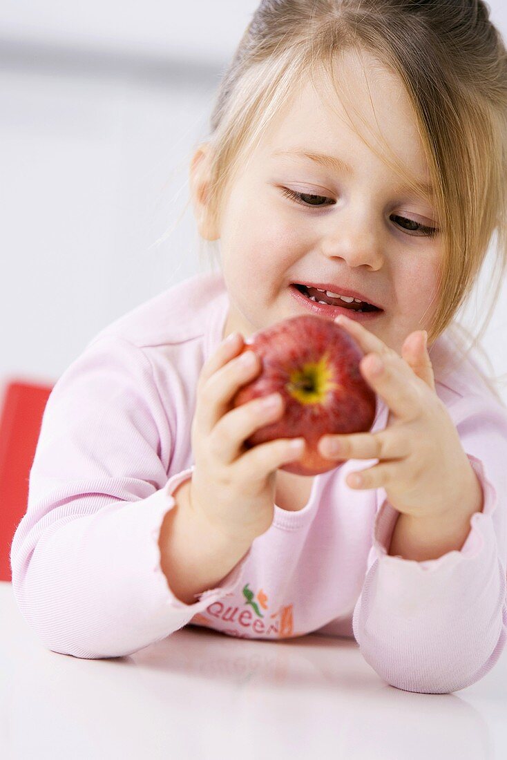 Kleines Mädchen hält einen Apfel