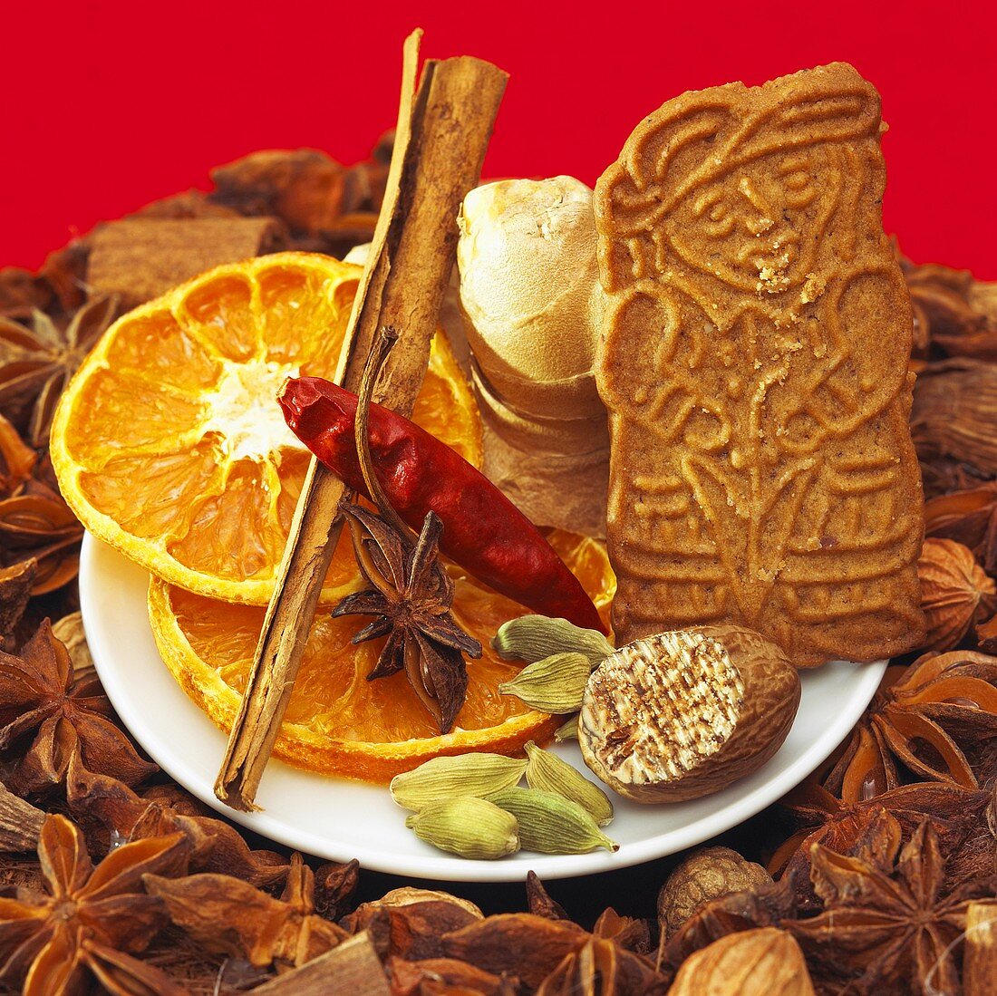 Christmas spices, dried orange slices & spekulatius cookie on plate