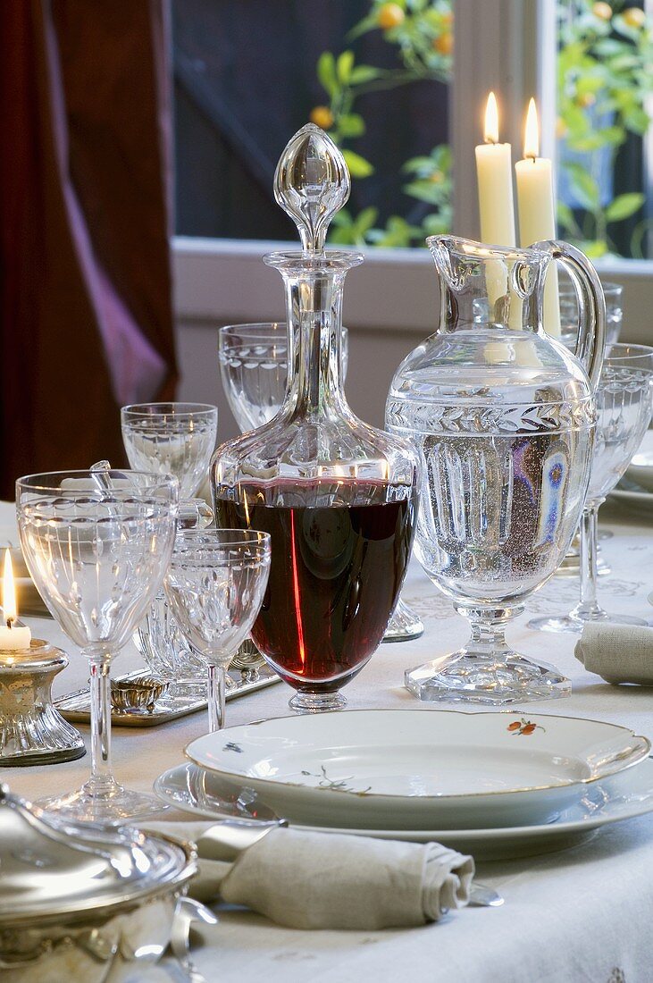 Festive place-setting with crystal glasses and red wine