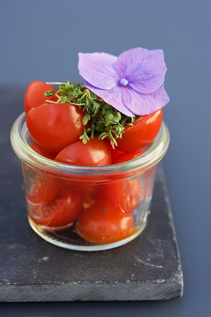 Halbe Kirschtomaten mit Kresse in einem Glas