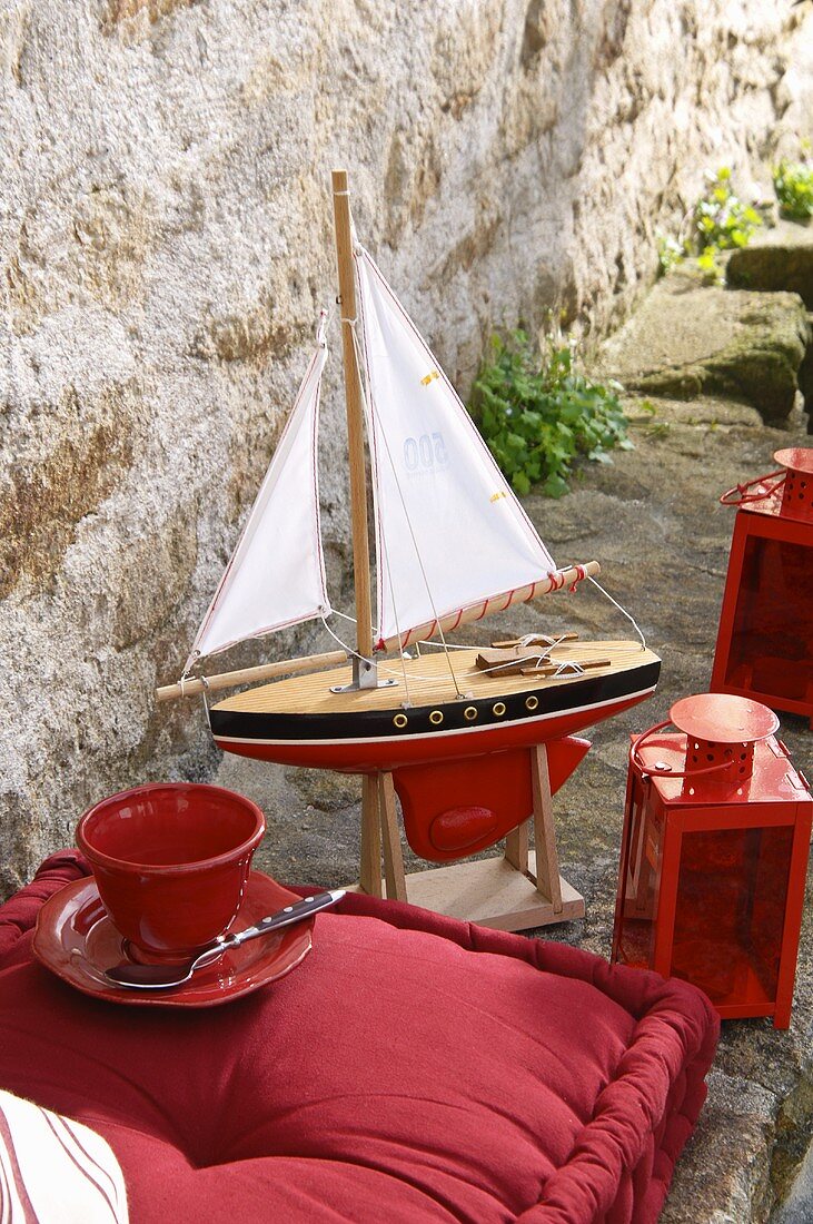 Floor cushion, lantern and model sailing boat