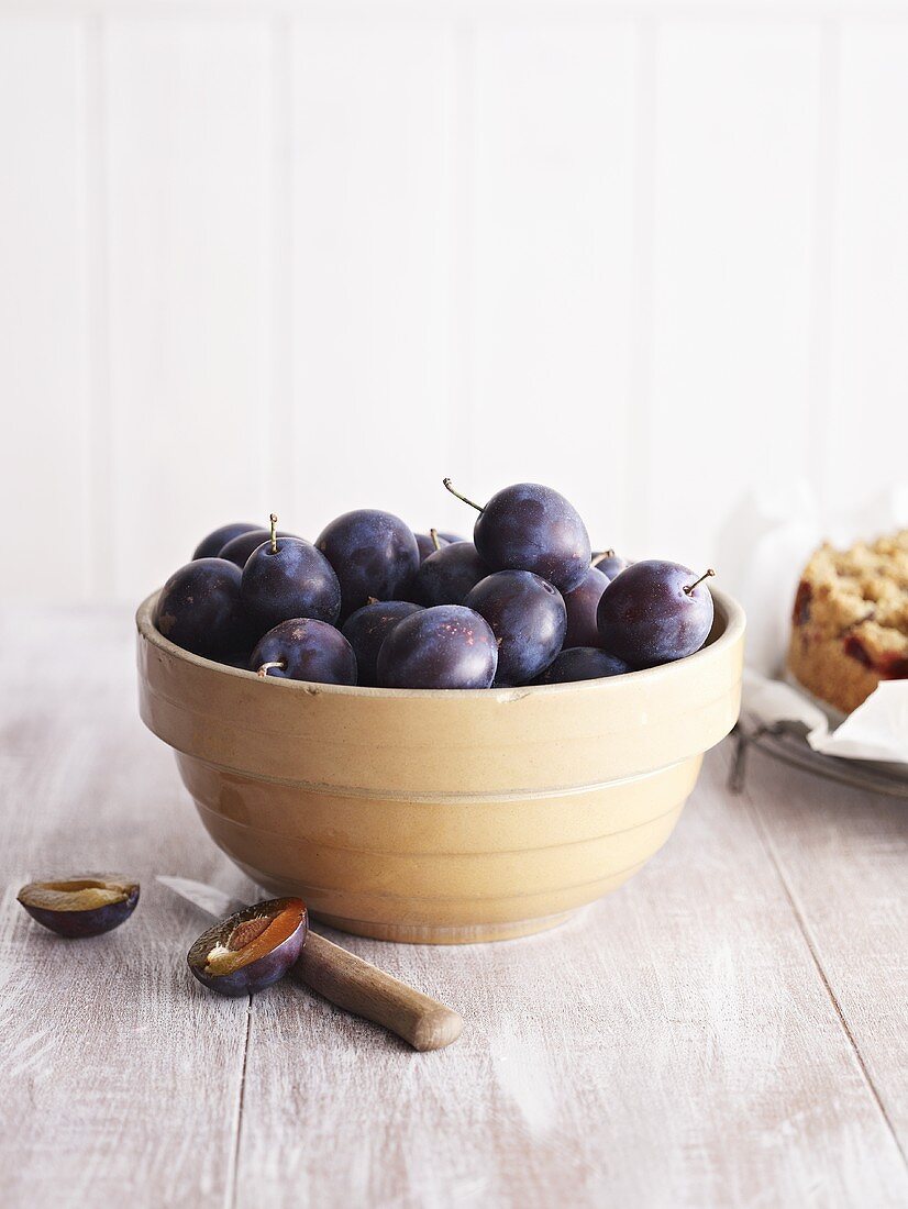 Fresh plums in bowl, plum cake beside it