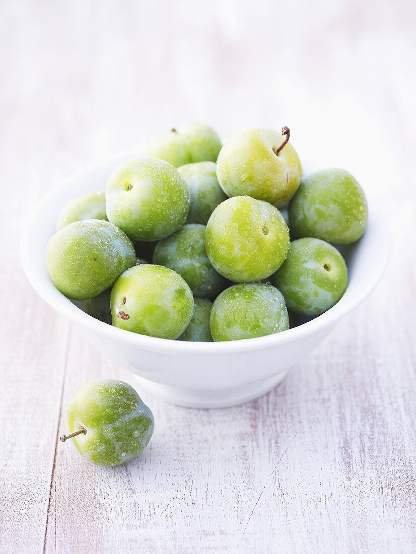 Greengages in bowl, one beside it