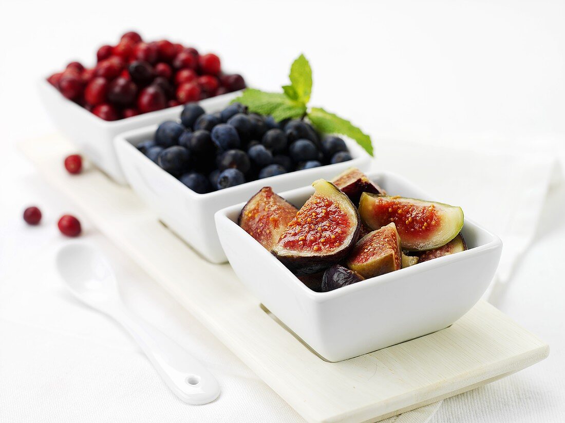 Figs, blueberries and cranberries in dishes