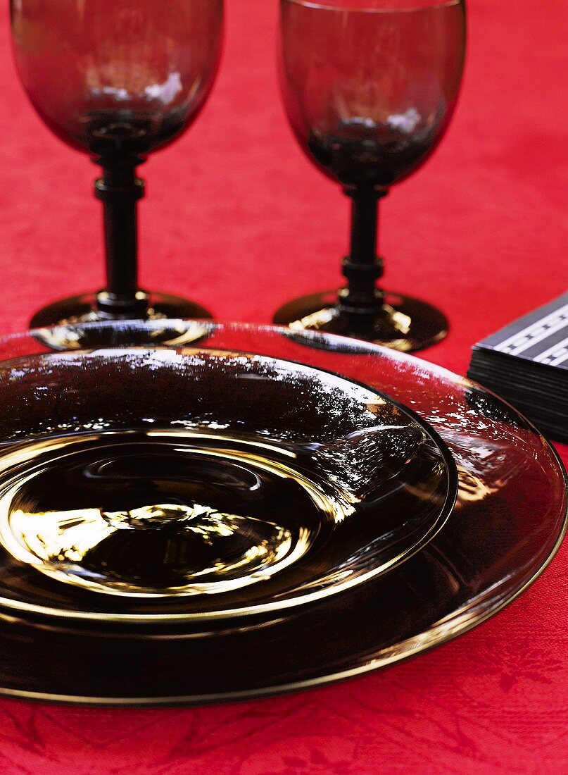 Place-setting with black glass plates and white glasses