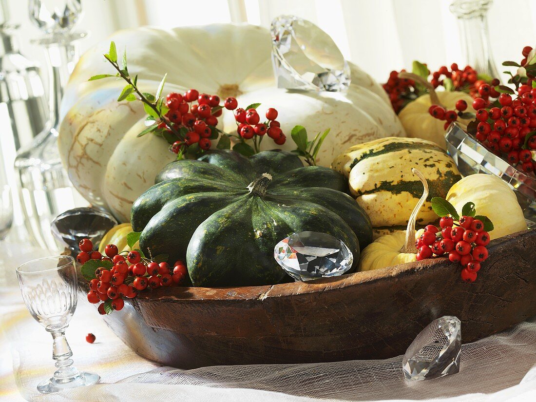 Holzschale mit Kürbissen und Feuerdornbeeren als herbstliche Tischdeko