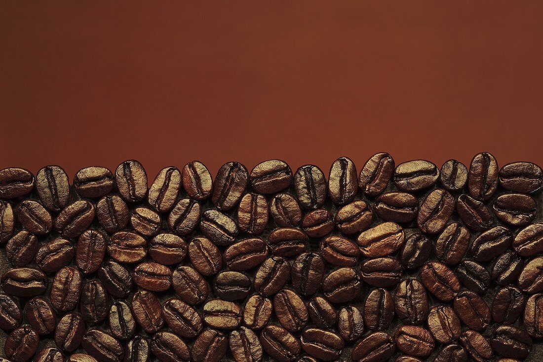 Coffee beans against brown background