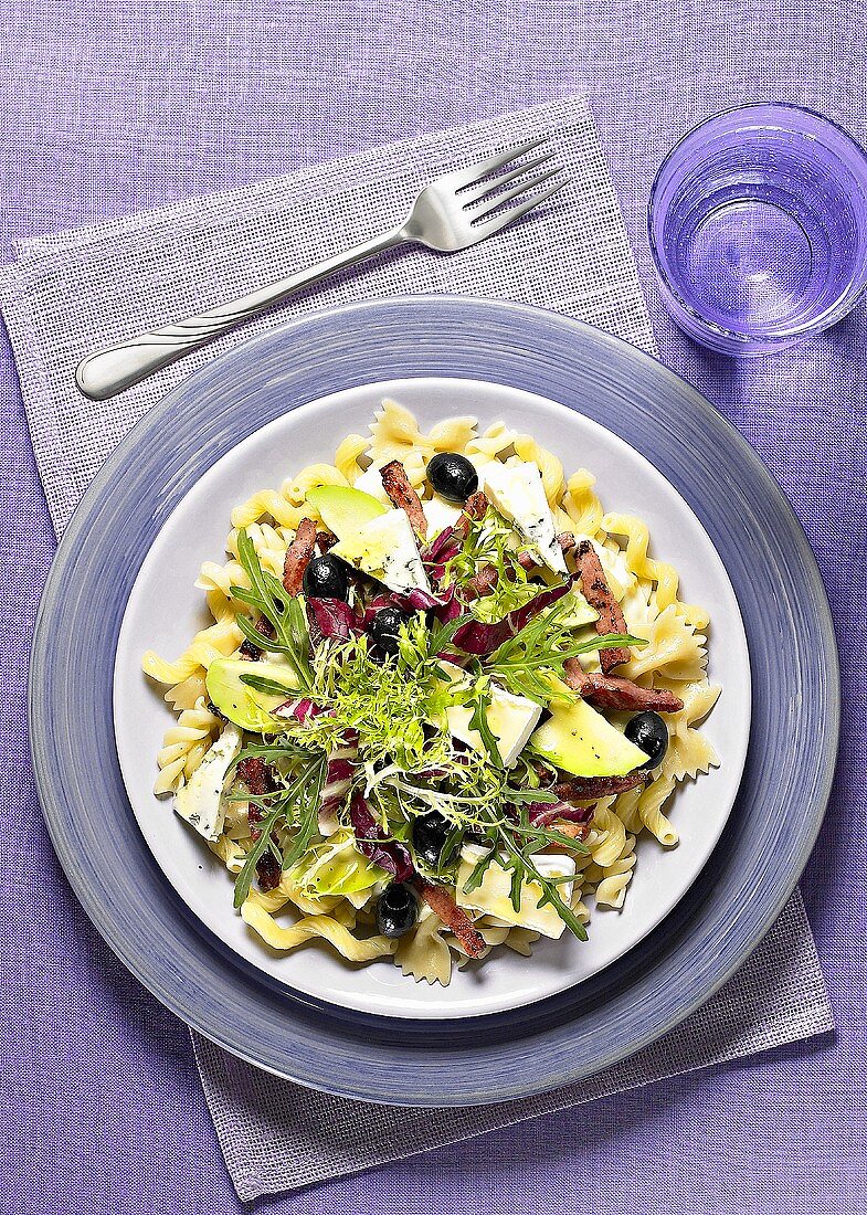 Pasta with ham, cheese, olives and salad leaves