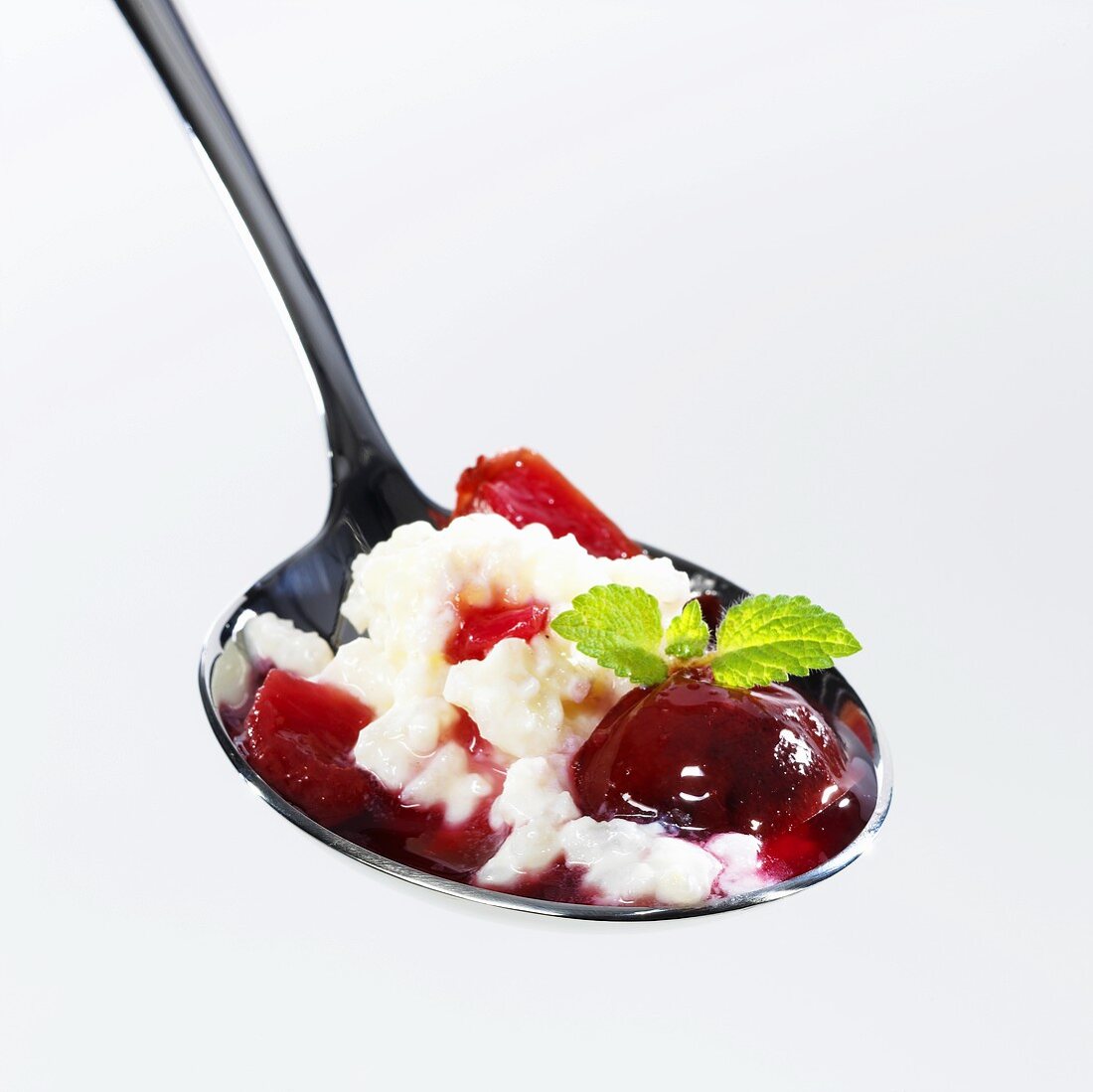Rice pudding with plum compote on spoon