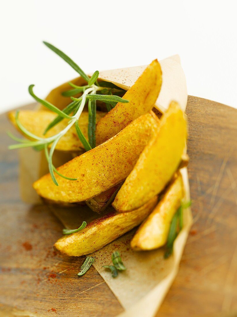 Potato wedges with paprika & rosemary in baking parchment cone
