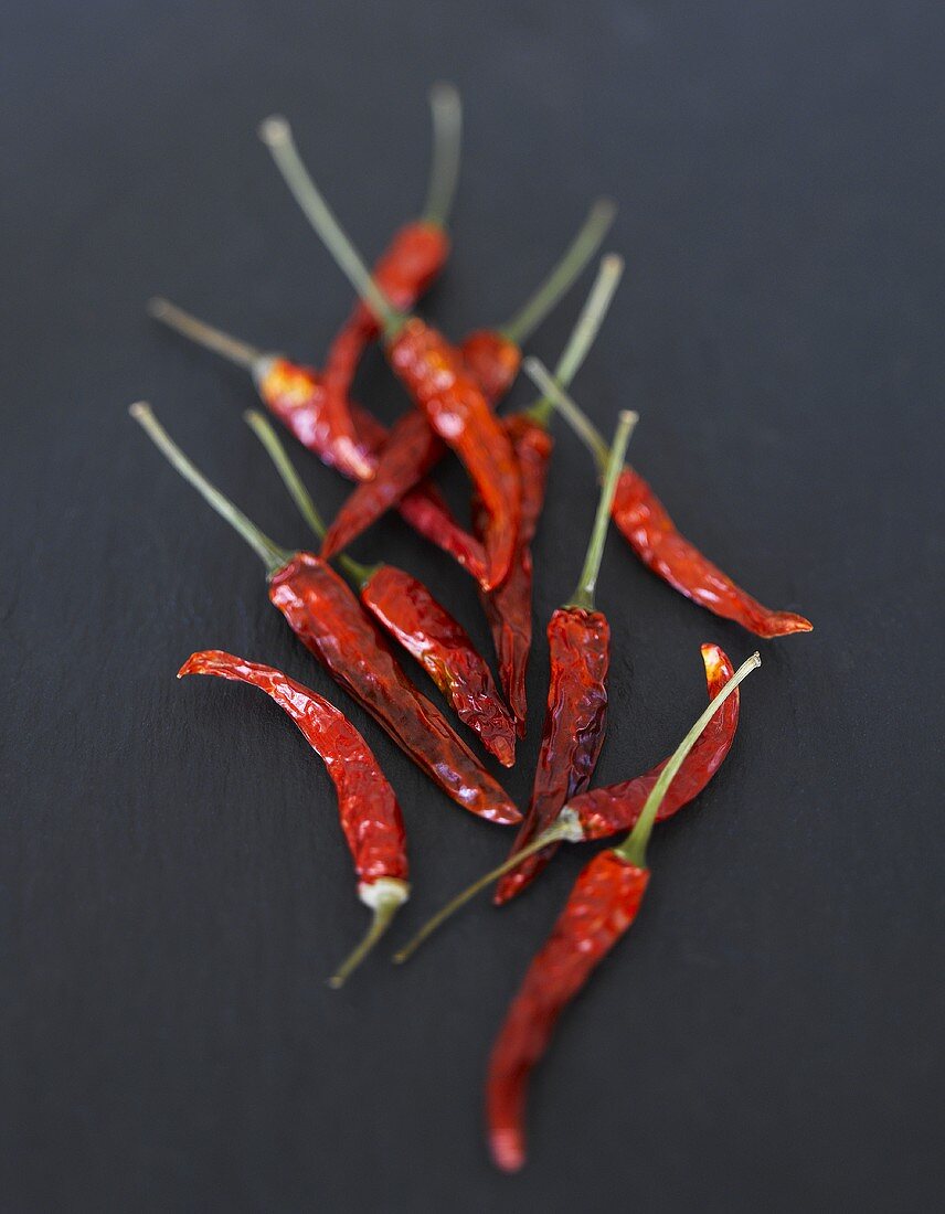 Several dried chillies on slate