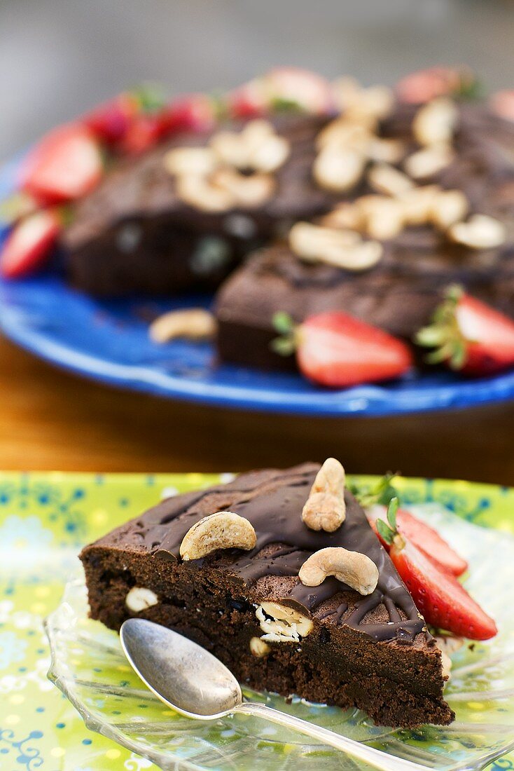 Stück Schokoladentorte mit Cashewkernen und Erdbeeren