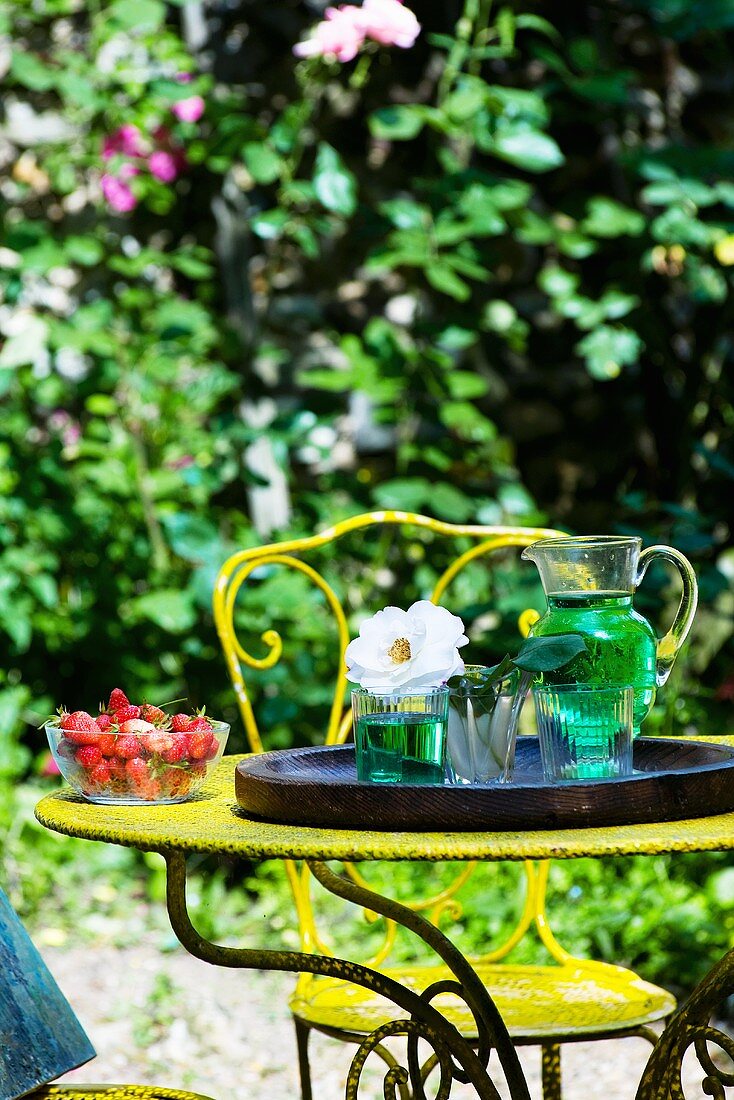 Getränke und Erdbeeren auf einem Gartentisch