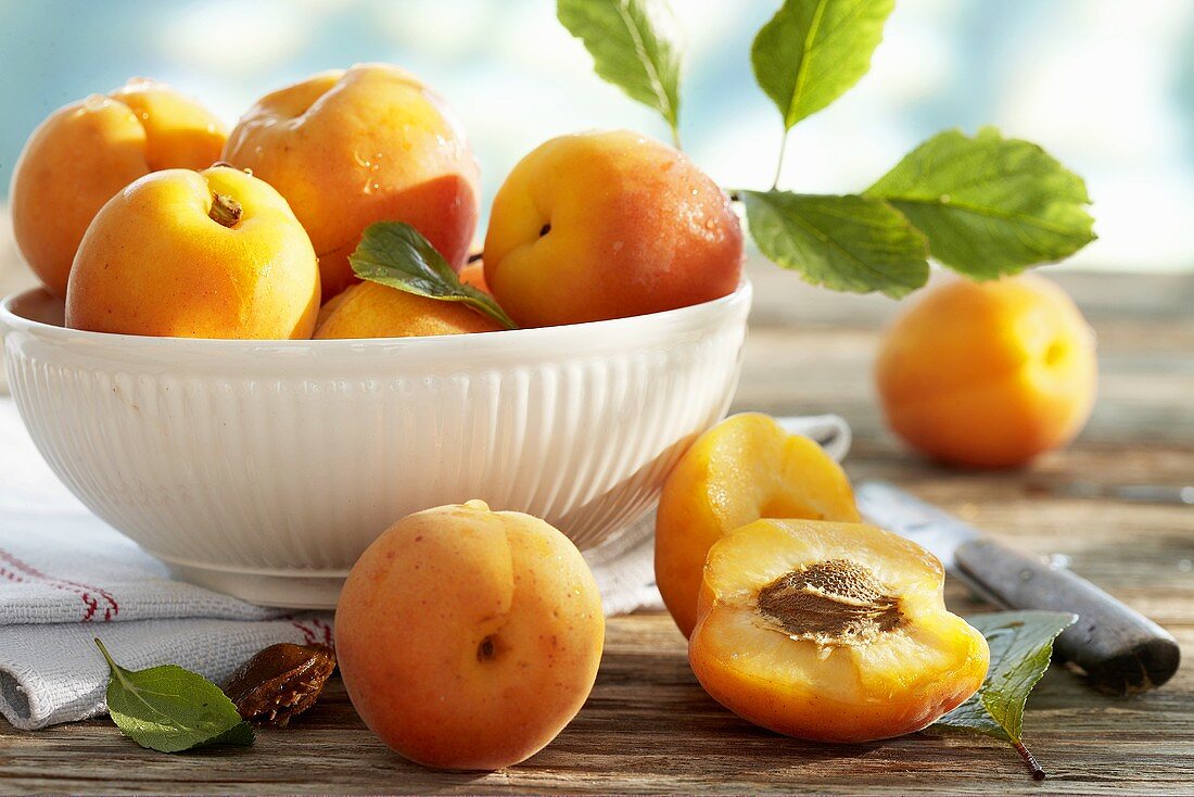 Fresh apricots in and beside bowl