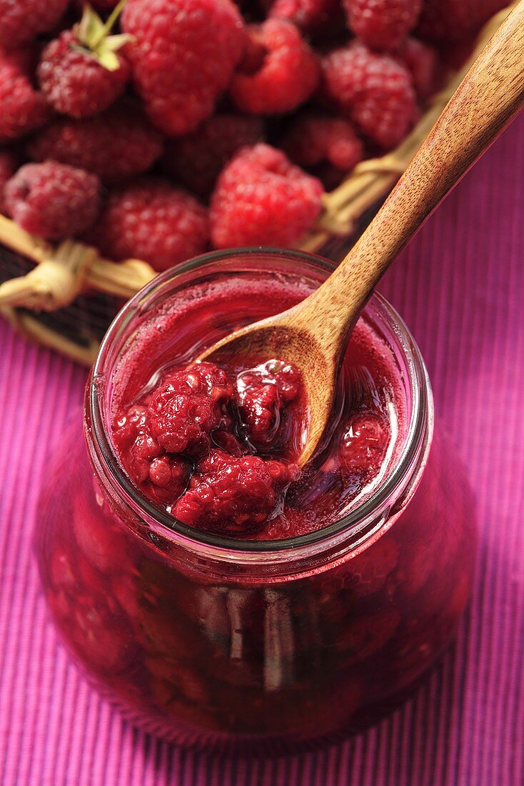 Himbeermarmelade im Glas mit Holzlöffel