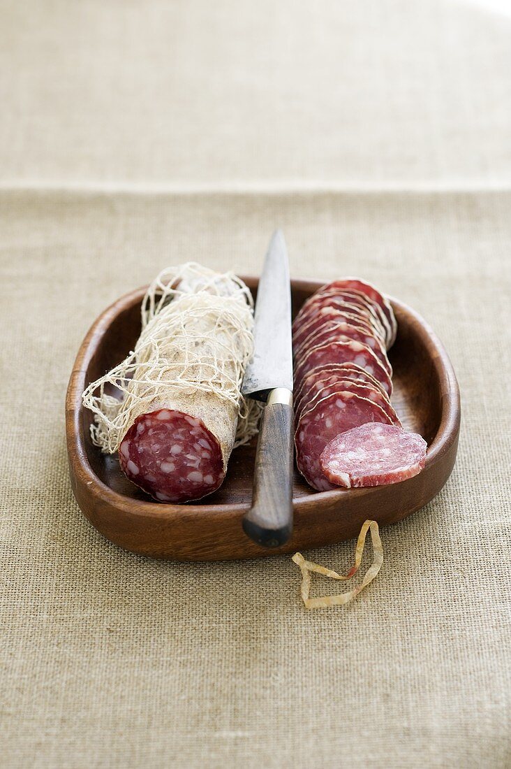 Saucissons in wooden dish with knife