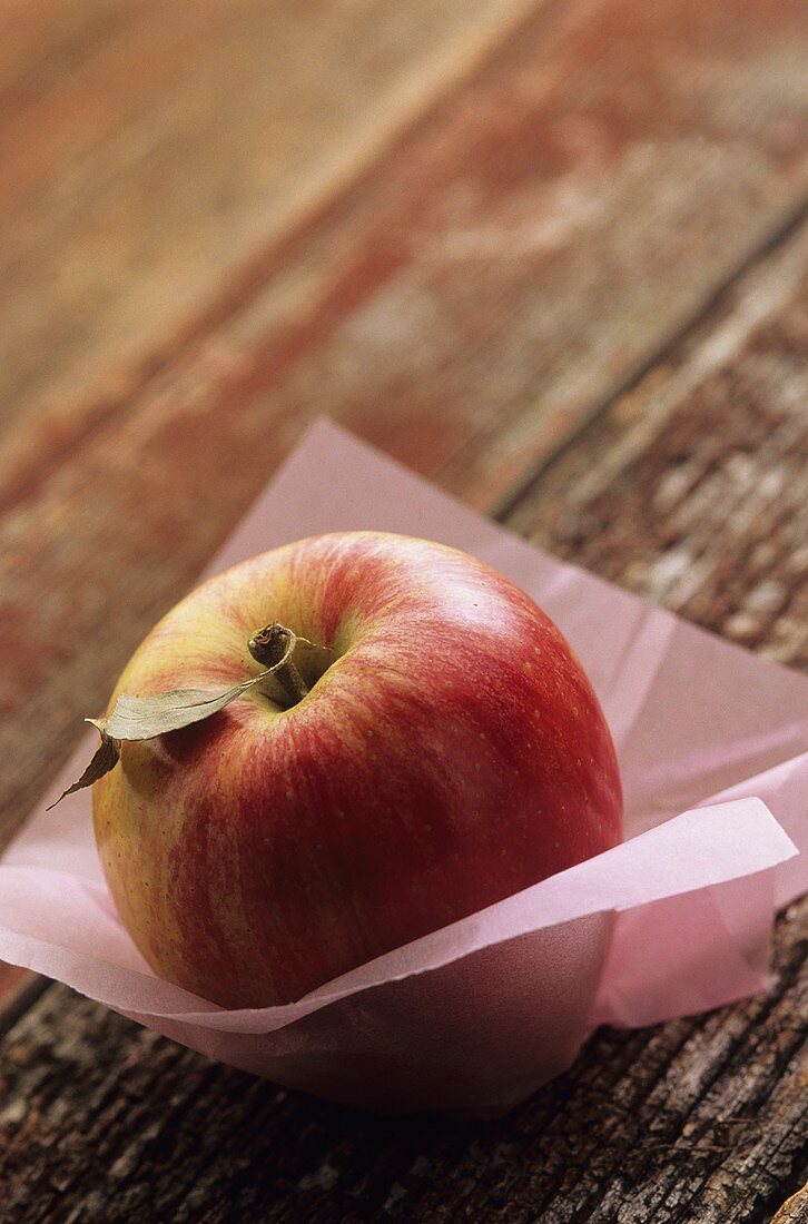Red apple on pink paper