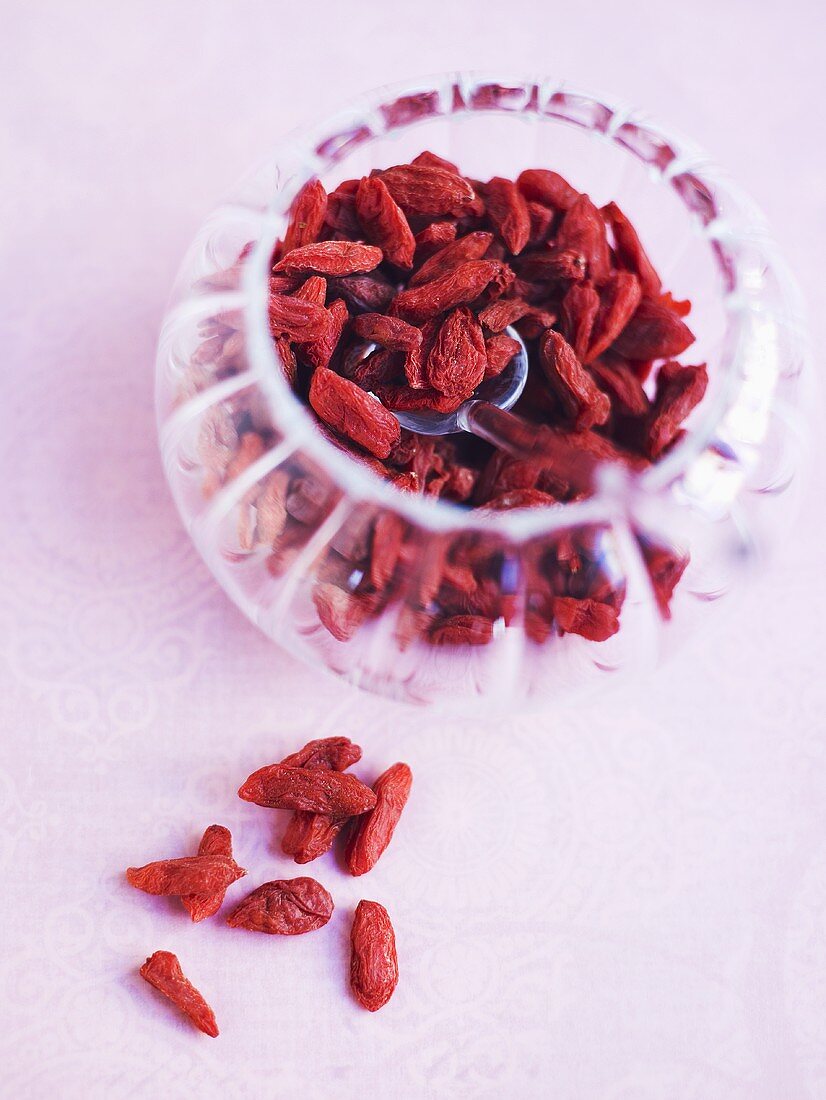 Goji berries in and beside a small glass bowl
