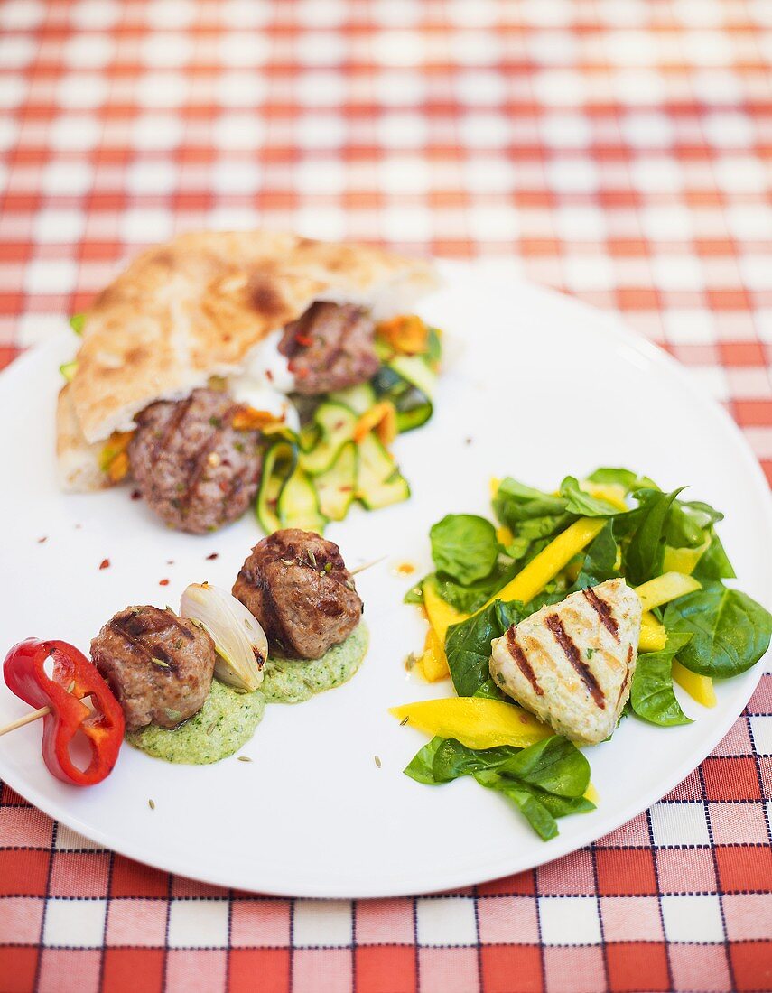 Meat kebab, meatballs & pork fillet with vegetables, pesto & salad leaves