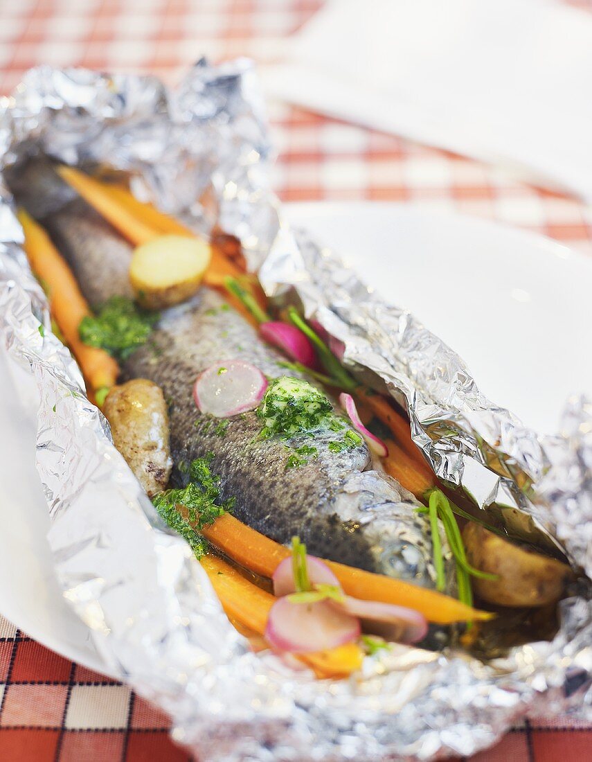 Grilled trout and vegetables in aluminium foil