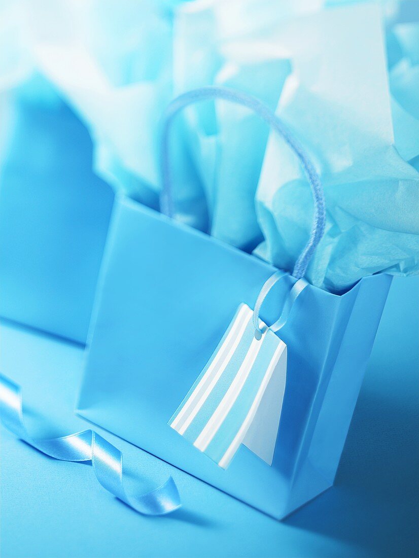 Blaue Geschenktüte und Geschenkpapier