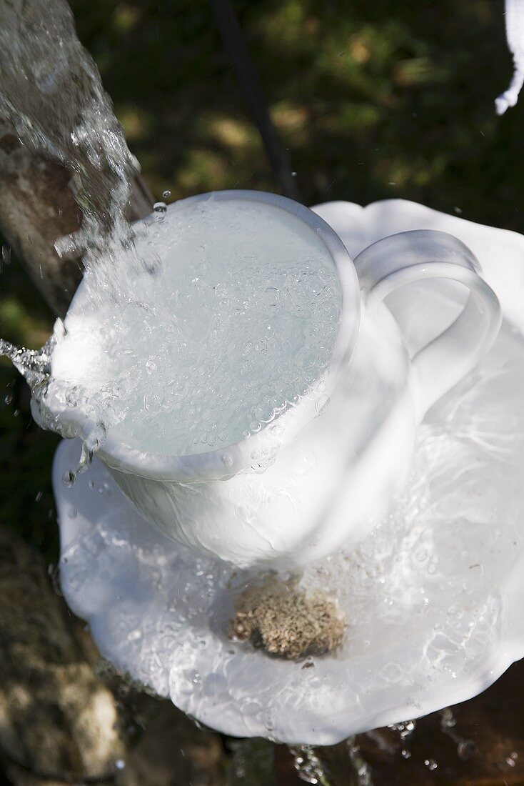 White coffee cup and saucer in water