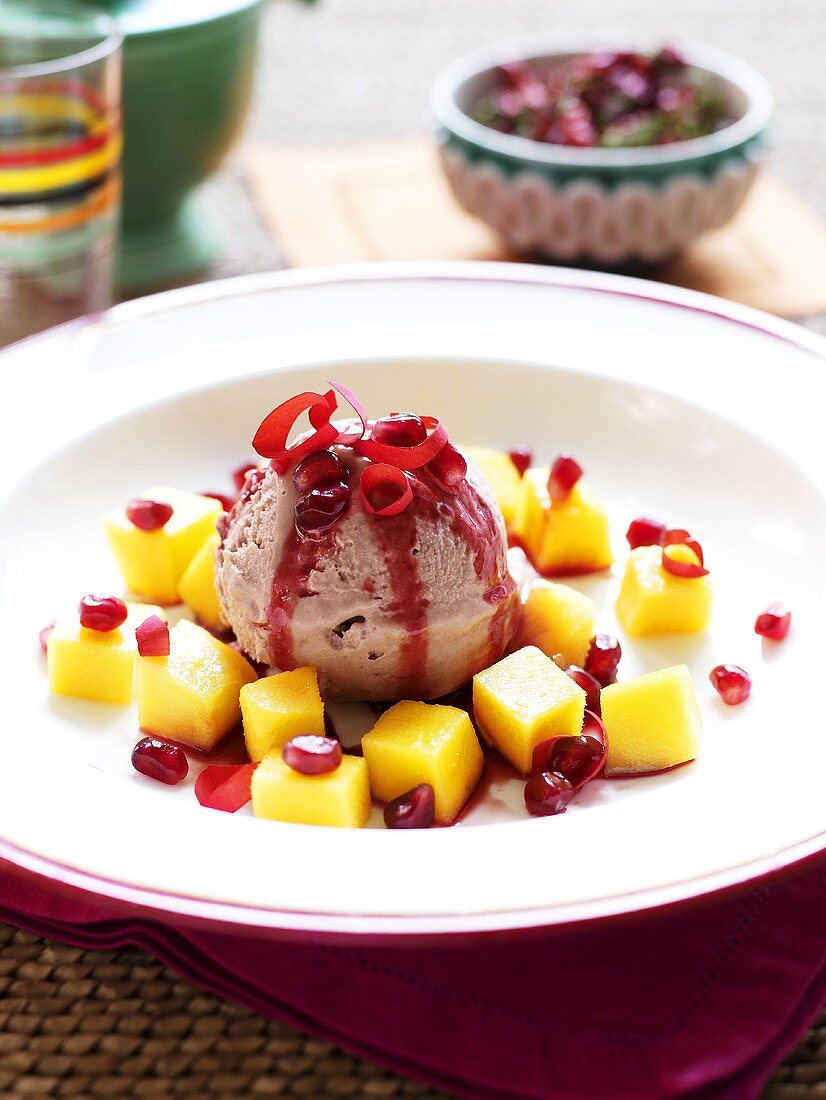 Raspberry ice cream with mango and pomegranate sauce