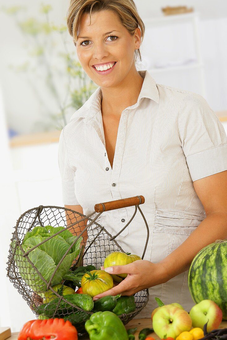 Frau hält Drahtkorb mit Bio-Gemüse
