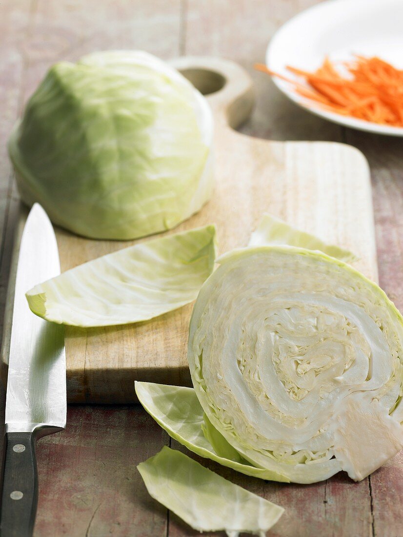 White cabbage, halved, on chopping board