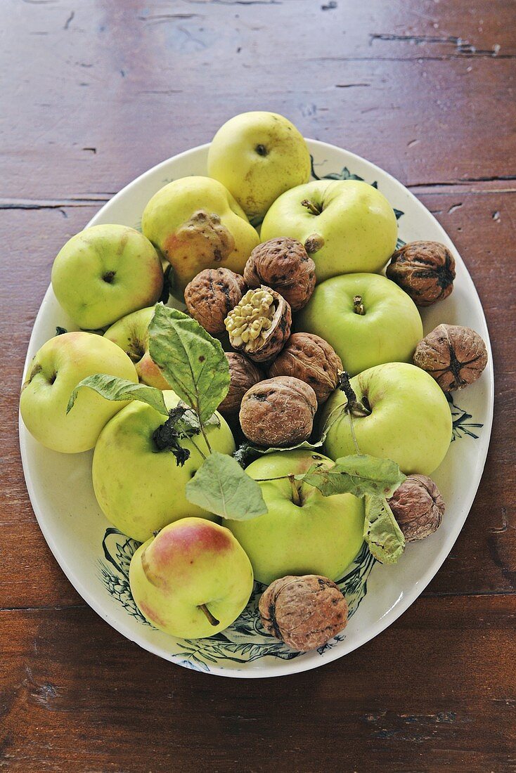 Bio-Äpfel und Walnüsse auf Teller