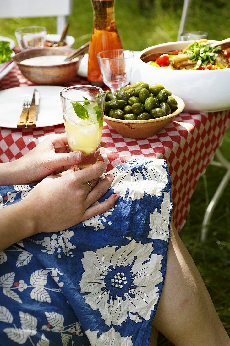 Frau mit Orangina-Cocktail bei italienischer Grillparty