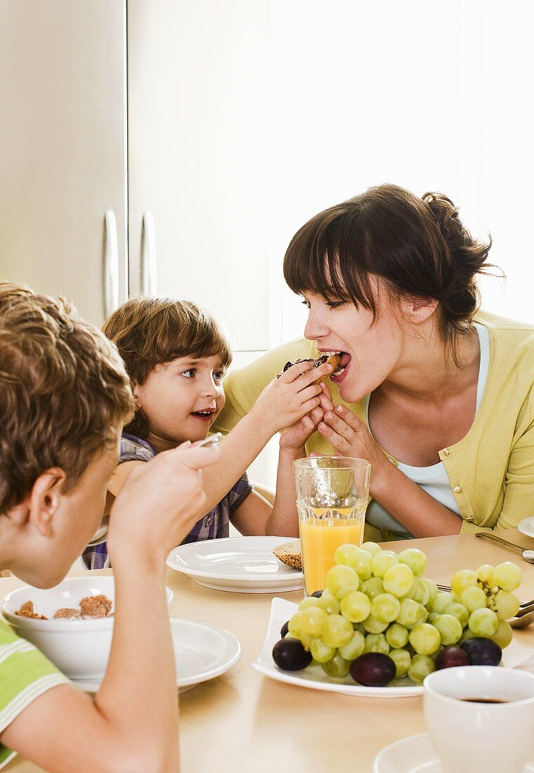Mother having breakfast with two children