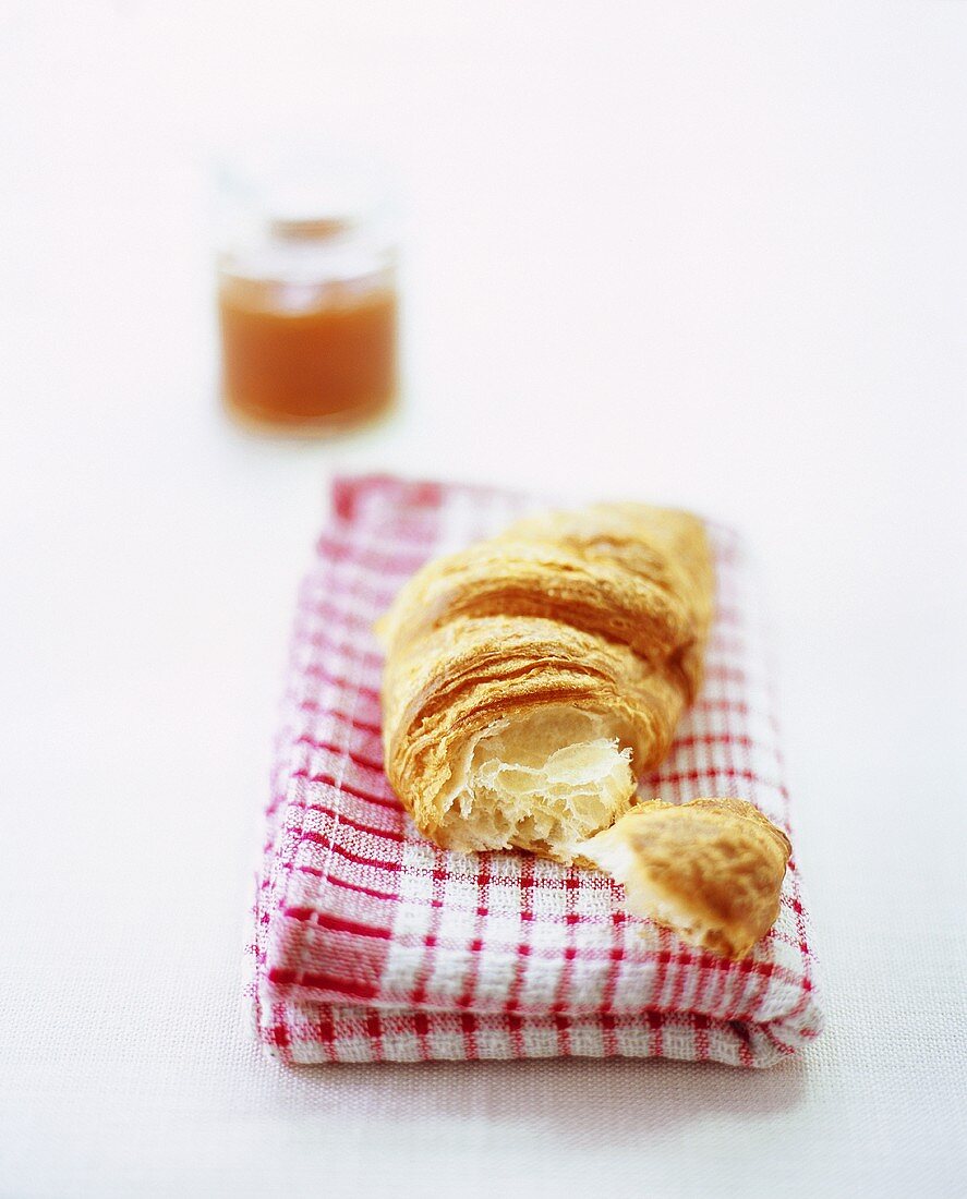 Ein Croissant und Aprikosenmarmelade